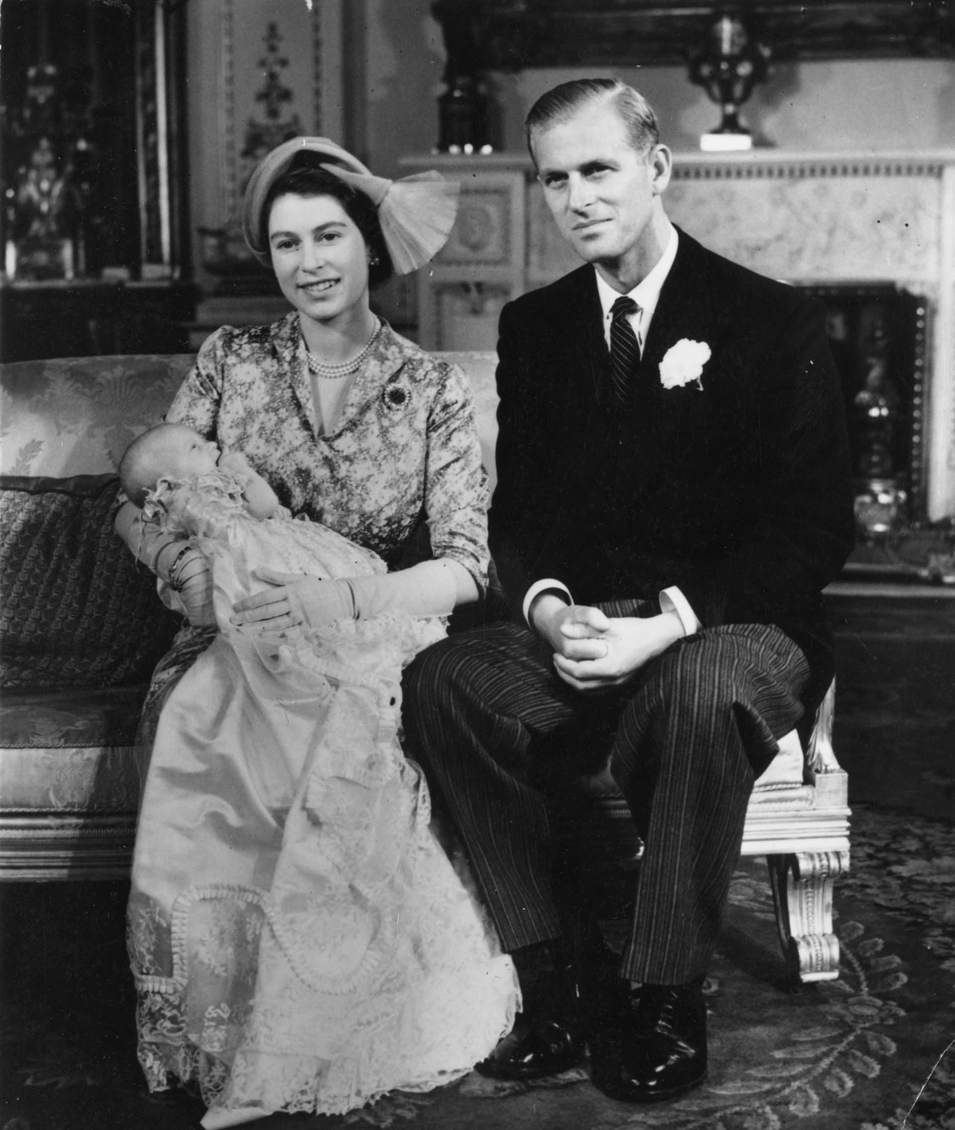 21 de octubre de 1950: la princesa Isabel con su hija, la princesa Ana, en brazos en su bautizo en el Palacio de Buckingham, con el duque de Edimburgo a su lado (Topical Press Agency/Getty Images)

