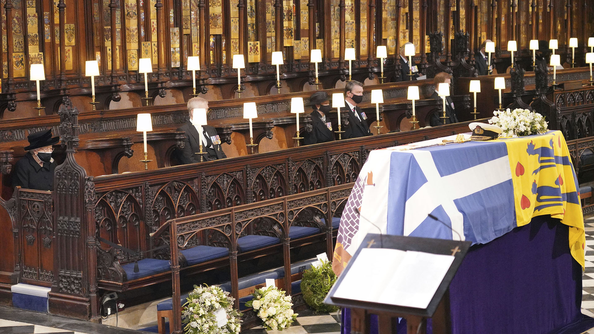La reina Isabel II de Gran Bretaña mira el ataúd cubierto con la bandera en la capilla de San Jorge durante el funeral del príncipe Felipe, el hombre que había estado al lado su lado durante 73 años. Felipe murió el 9 de abril a la edad de 99 años (Jonathan Brady/Piscina vía AP)

