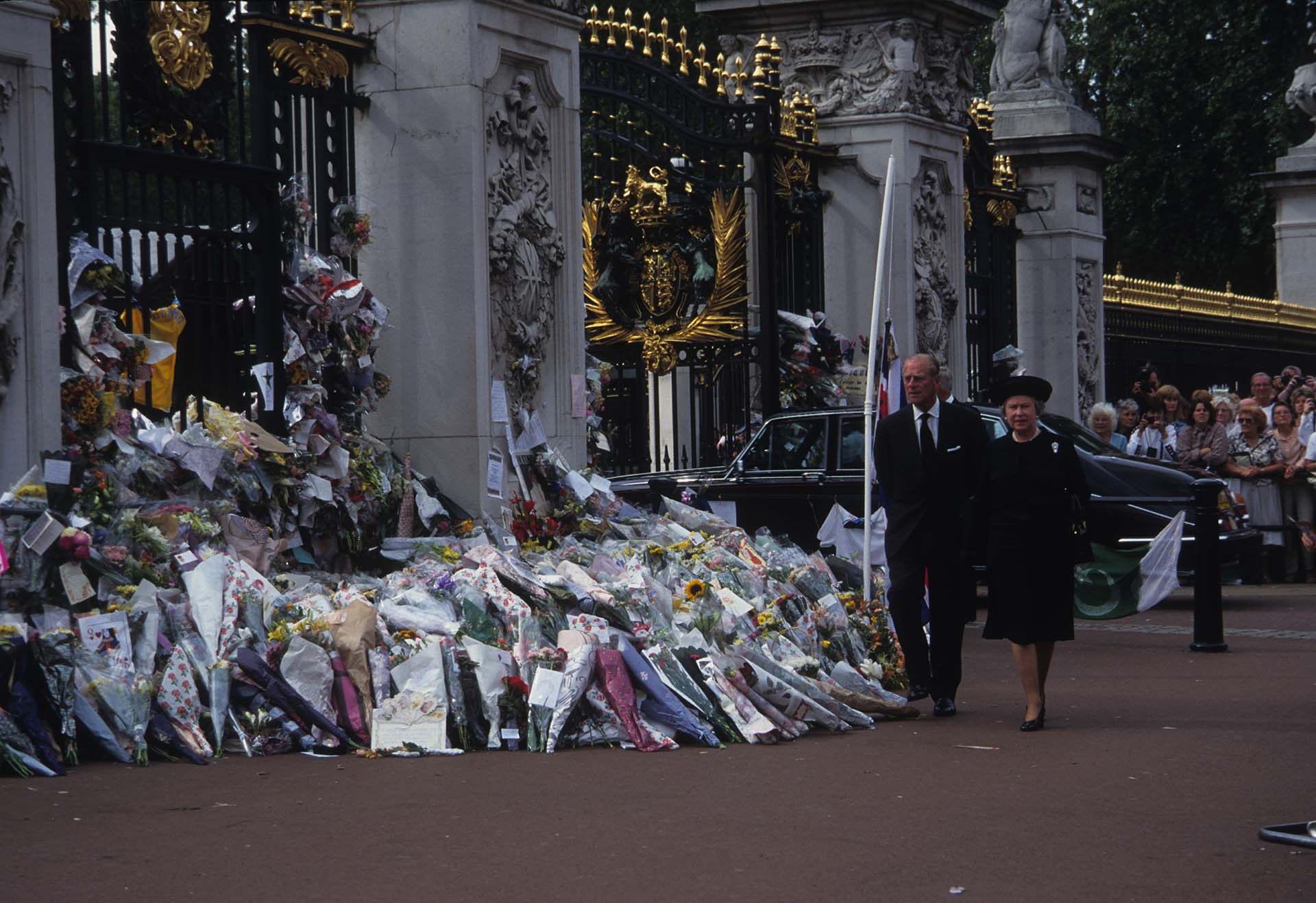 Isabel junto a su esposo observa las flores que la gente dejó para recordar a Diana (John Shelley Collection/Avalon/Getty Images)