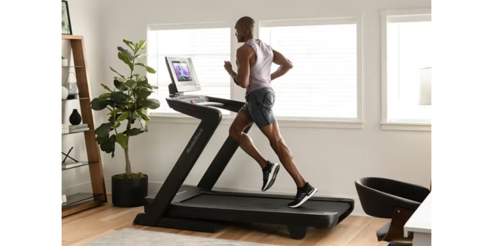 Someone running on the NordicTrack Commercial 1750 in a home gym setup.