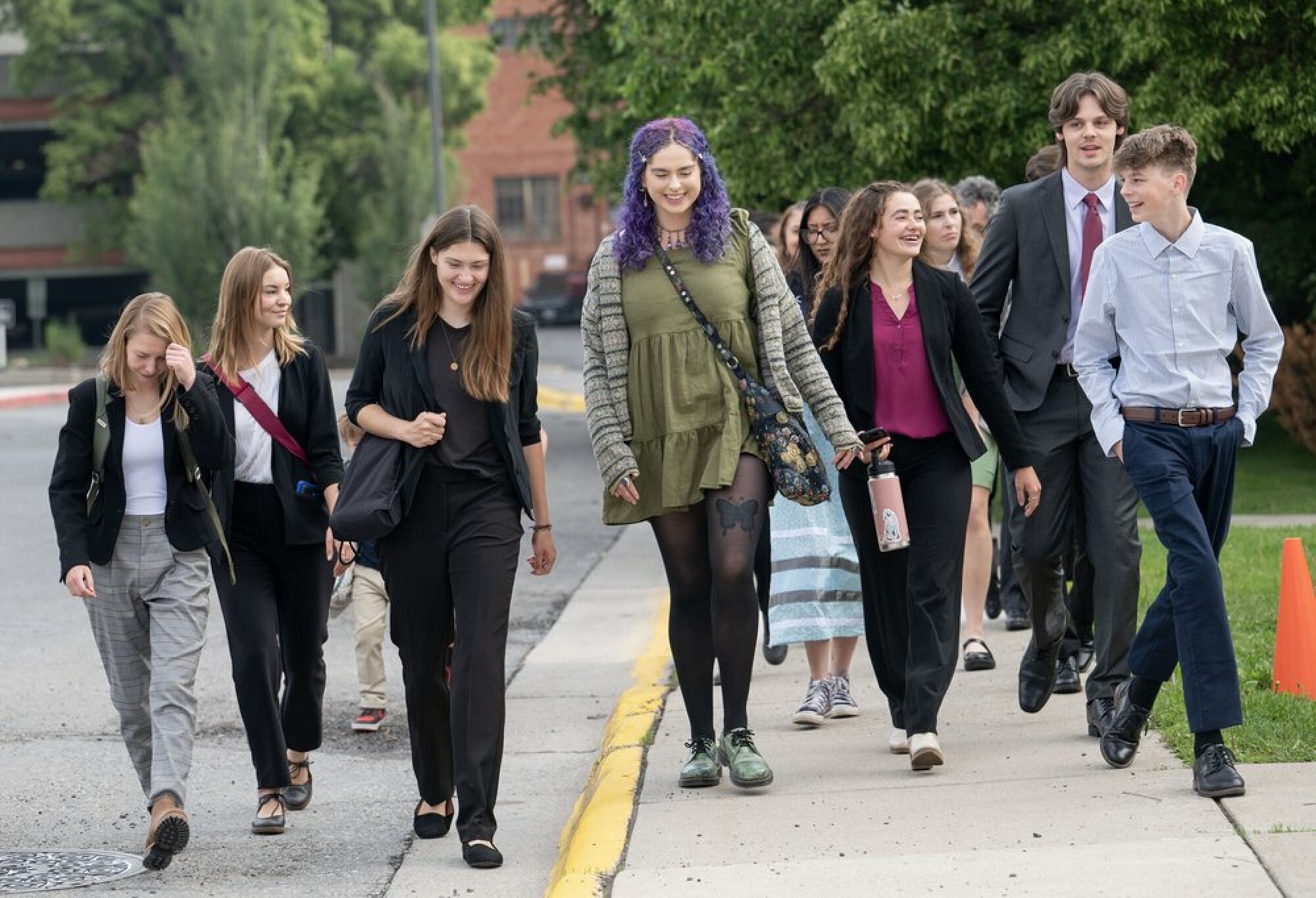 A large group of youth plaintiffs walk down a street.