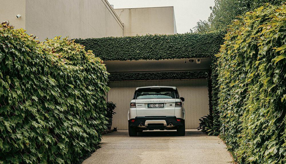 A car parked in a garage surrounded by plants